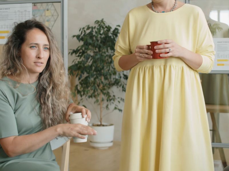 devojke u haljinama razgovaraju u kancelariji uz kafu