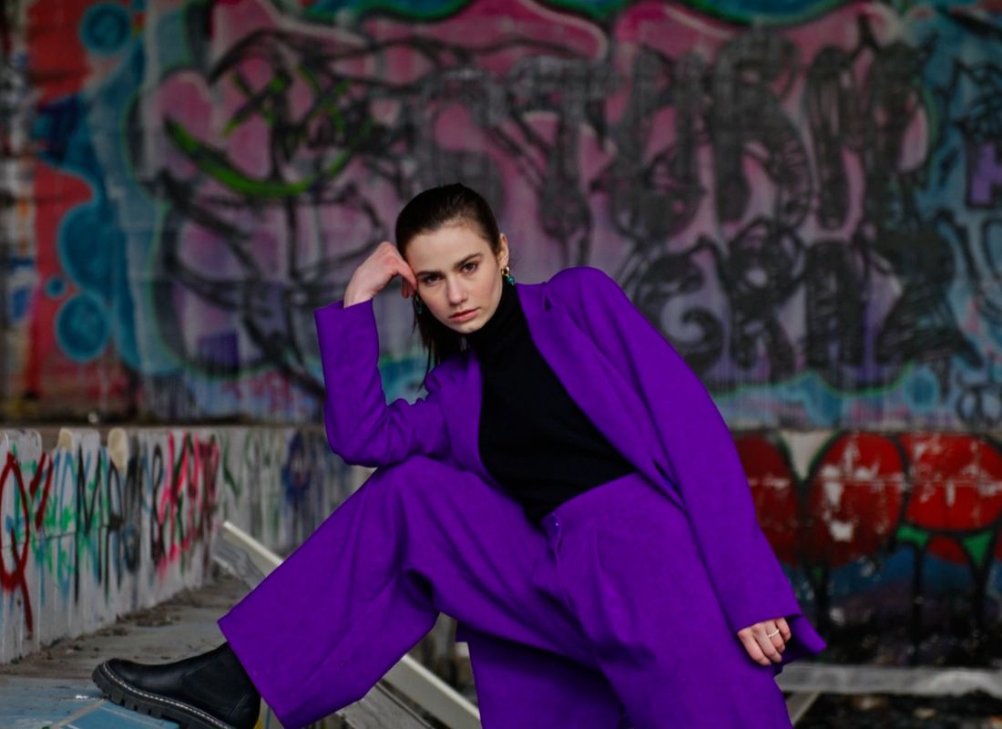 devojka u odelu boje lavande i crnoj rolci pozira