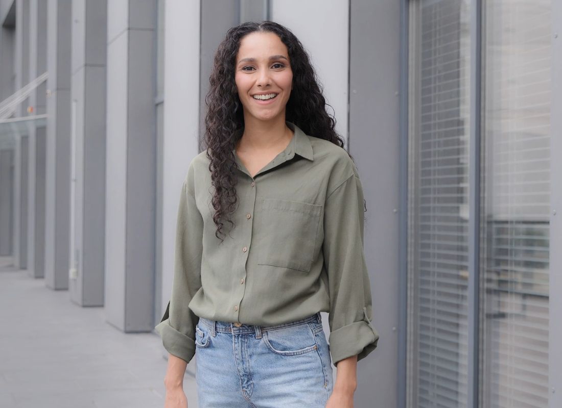 devojka pozira u maslinasto zelenoj košulji i farmerkama